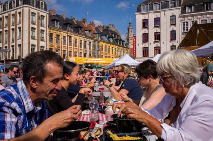 Photographie de rue à Lille - des touristes mangent des moules frites sur la place Rihour